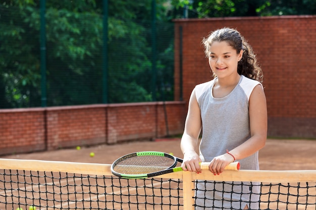 Tienermeisje in sportieve outfit tennissen