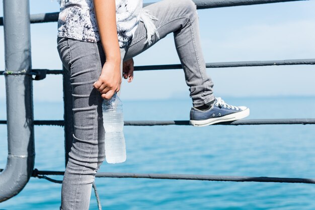 Tienermeisje in unieke stijl met trendy sneaker schoen met fles koud water in zonnige dag