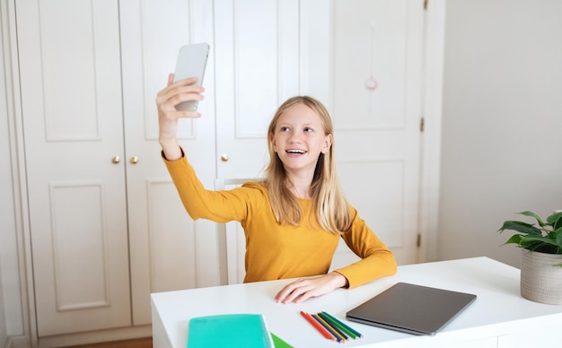 Tienermeisje maakt selfie aan het bureau in het kantoor.