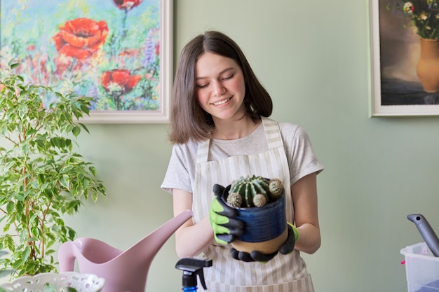 Tienermeisje met cactus in pot. Hobby's en vrije tijd, tuinieren, kamerplant, potvriendenconcept