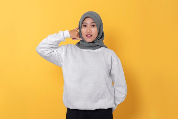 tienermeisje met hijab en witte trui glimlachend gelukkig doen roepnaam op blauwe achtergrond
