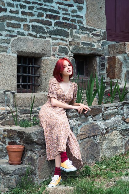 Tienermeisje met rood haar in zomerjurk