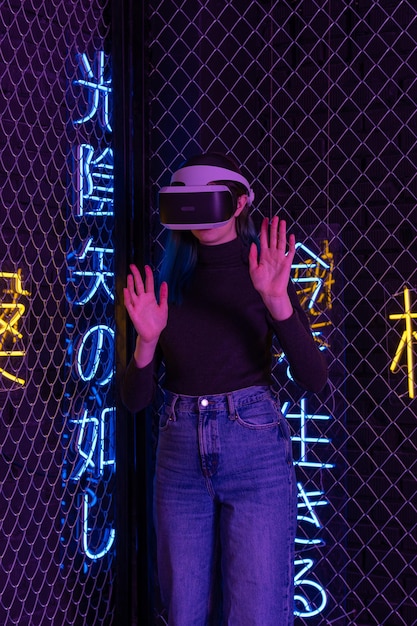 Tienermeisje met vr-headset is in virtual reality cyberspace futuristische neon kleurrijke achtergrond Het concept van het metaverse virtual reality virtuele sociale universum Toekomstige digitale technologieën