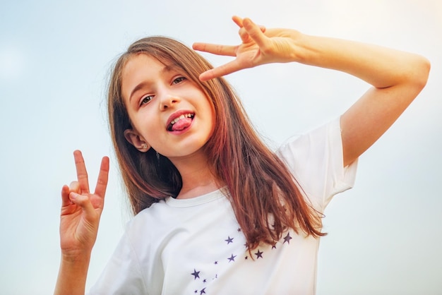 Tienermeisje positief portret tegen de hemel op een zonnige dag Meisje 11 jaar oud