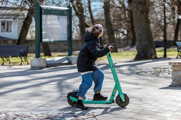 Tienermeisje rijden scooter op bestrating