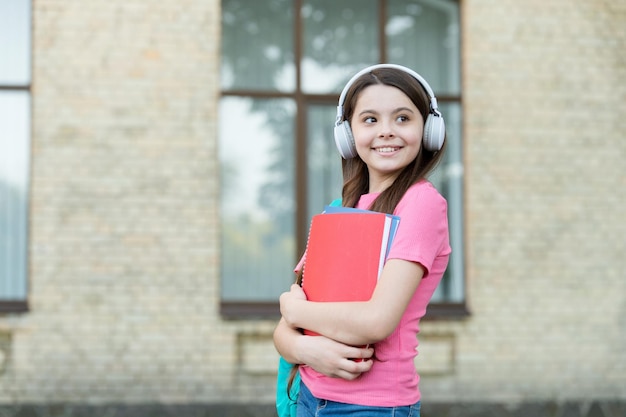 Tienermeisje schoolstudent met stereo koptelefoon nieuwe technologie, aandacht voor geluidsconcept.