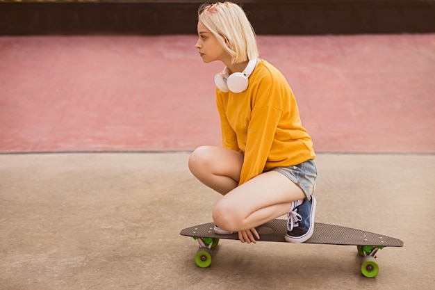 Tienermeisje skateboard rijden op straat