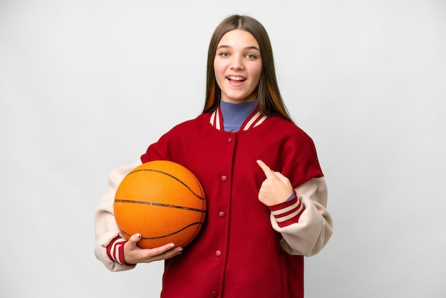 Tienermeisje speelt basketbal over geïsoleerde witte achtergrond met verrassende gelaatsuitdrukking