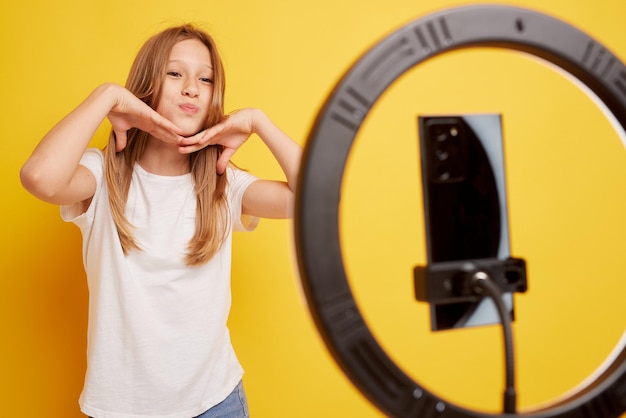 Tienermeisje spreken voor camera voor vlog geïsoleerd op gele achtergrond tiener werkt als