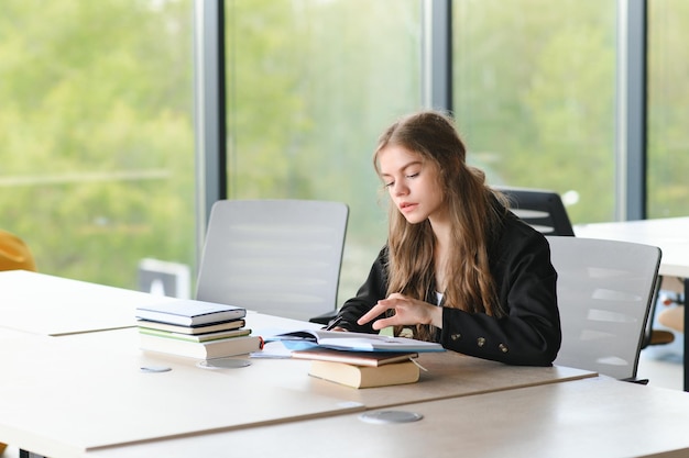 Tienermeisje studeren met leerboek schrijven essay leren in de klas