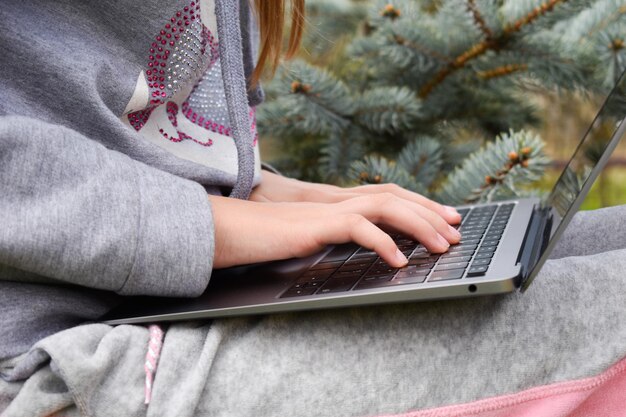 Tienermeisje studeren op een laptop Afstandsonderwijs Gelukkig schoolmeisje in Park met computer