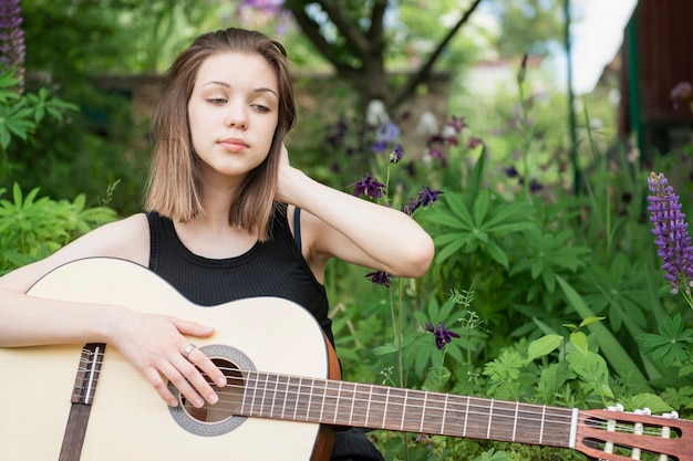 Foto tienermeisje zit met een gitaar