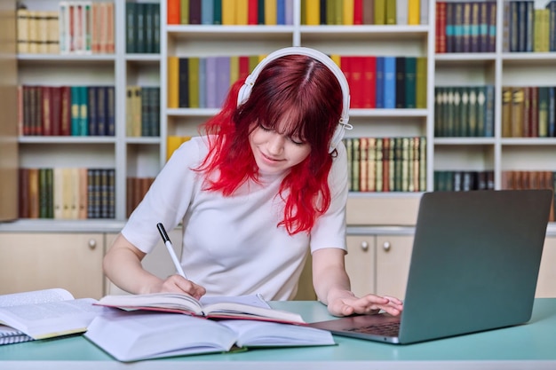 Tieners die in de bibliotheek studeren met een laptop