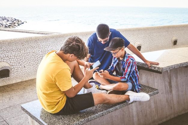 Tieners die samen een smartphone gebruiken, glimlachende tieners die sociale media online surfen, jongens die video's kijken.