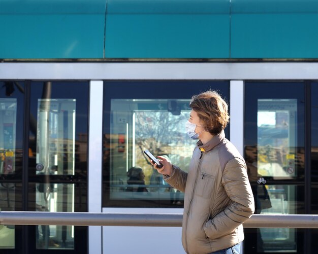 Tieners die sms'jes typen met hun smartphone Tramstation