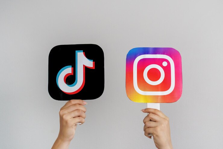 Foto tieners handen houden tiktok en instagram logo's op grijze achtergrond concept van tieners