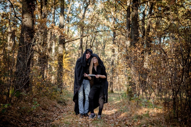 Tieners in halloween-kostuums in het bos.