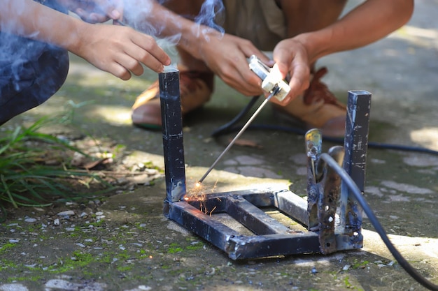 Foto tieners leren staal lassen met onzorgvuldig gebruik van gereedschap