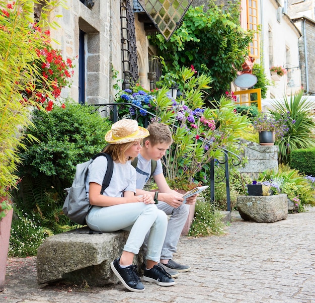 Tieners reizen concept Kinderen met kaart in de straat van een oude stad RochefortenTerre Frankrijk