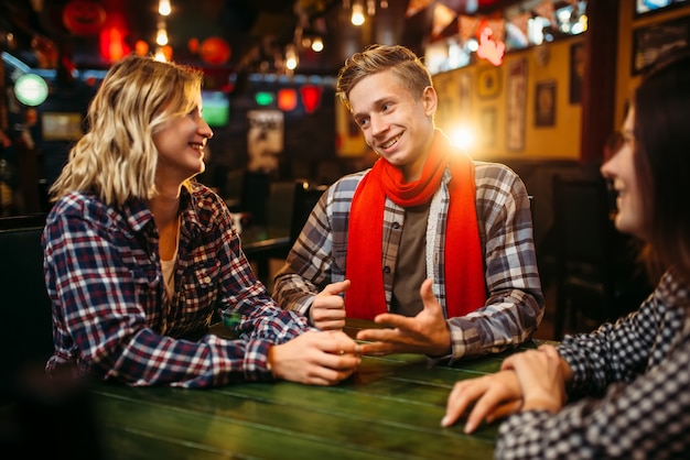 Tieners zitten aan de tafel in de sportbar