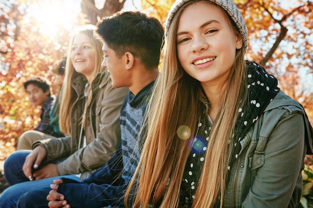 Foto tienersgroep en portret in het park meisje en diversiteit op vakantie natuur en ontspannen bij bomen jeugdcultuur gelukkige vrienden en generatie z schoolkinderen in zonnige bossen of tuin voor vakantie in canada