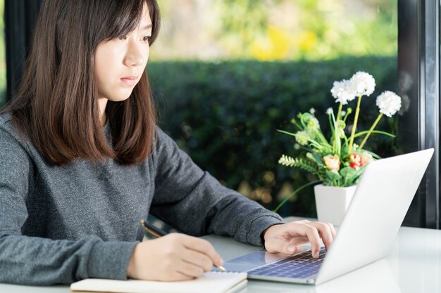 Tienerstudent die laptop met behulp van die thuiswerk thuis doen