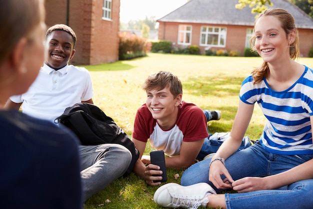 Tienerstudenten die buiten zitten en aan een project werken