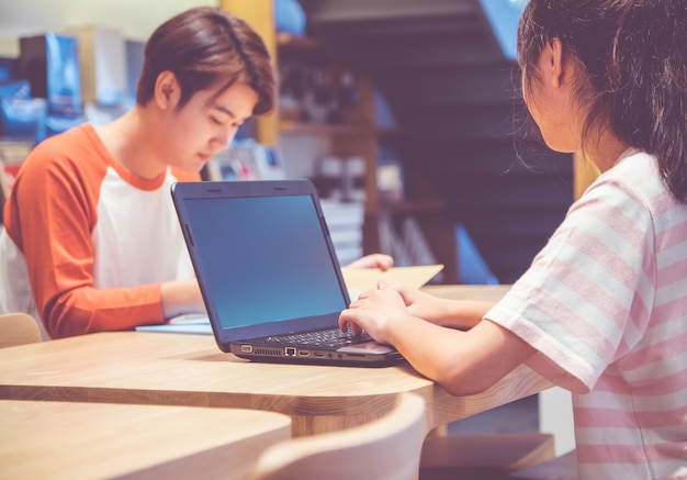 Tienerstudenten die samen studeren, gebruiken een laptop