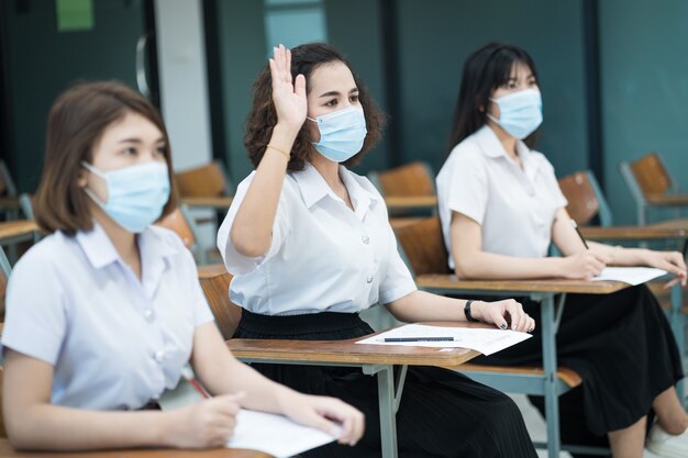 Tienerstudenten schrijven op het antwoordblad van het examenpapier in de klas