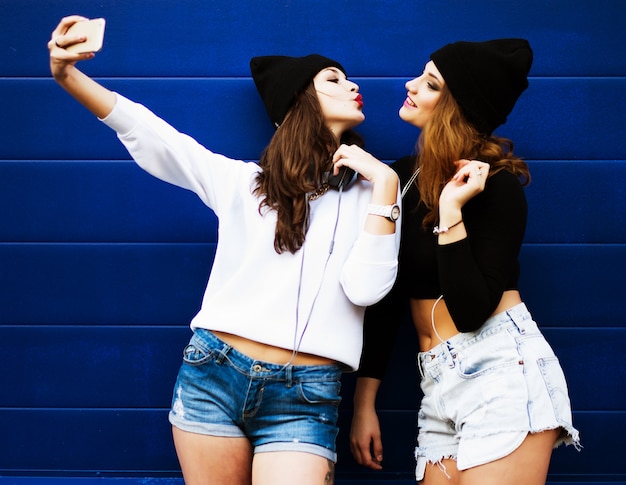 Tienervrienden maken buitenshuis selfie op een telefoon.