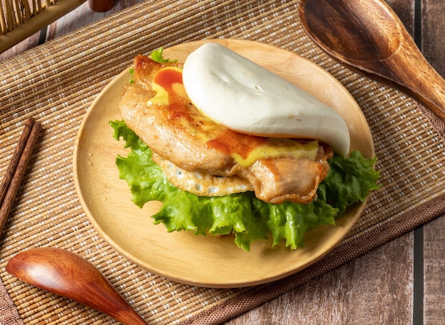 타이거 물린 황금 치킨 샌드위치는 대만 음식의 테이블 측면 보기에 고립 된 나무 접시에 제공