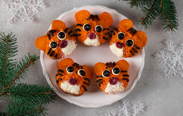 Tiger Sandwiches for New Year 2022 of carrot and black olives on white bread on gray background