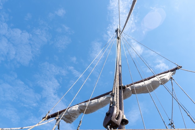Tigging en masten van een oud varend schip tegen de blauwe hemel met wolken. kopie ruimte.