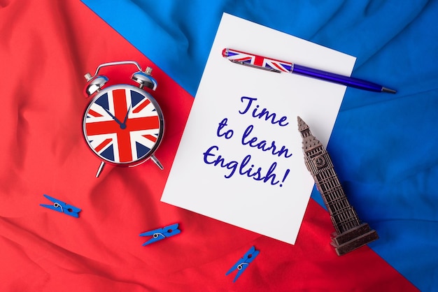 Tijd om Engelse Engelse vlagpen te leren met een klok en een kaart om berichten te schrijven Leer een nieuwe taal