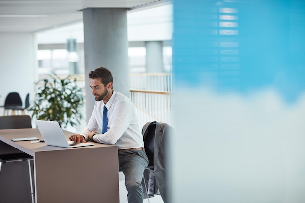 Tijd om te focussen en aan de slag te gaan Shot van een jonge zakenman die op een laptop in een kantoor werkt