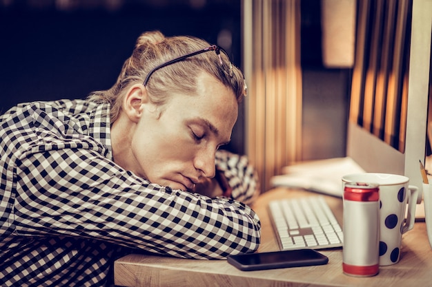 Foto tijd om te gaan slapen. uitgeput kantoormedewerker die de ogen dicht houdt terwijl hij droomt over vakantie