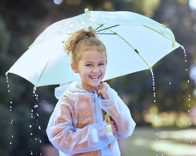 Tijd om wat kattenkwaad uit te halen Shot van een klein meisje dat speels in de regen staat en haar paraplu vasthoudt