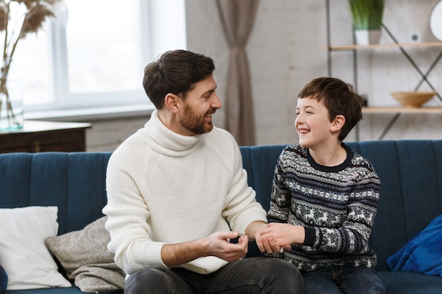 Tijd samen doorbrengen jonge vader met zijn zoontje, schattige jongen met vader die thuis speelt, gelukkig gezin