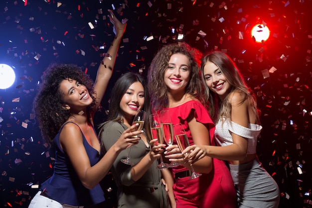 Tijd voor een feestje. Vier mooie stijlvolle vrouwen die het nieuwe jaar vieren in de nachtclub, kopieer ruimte