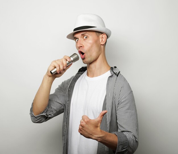 Tijd voor karaoke Jonge man zingt met microfoon