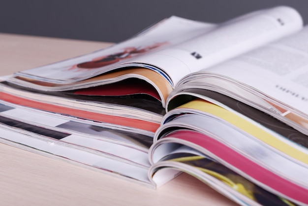 Tijdschriften op houten tafel op grijze achtergrond