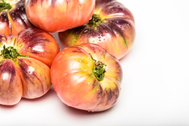 Tijgertomaat op een snijplank met basilicumbladeren op houten achtergrond kopieer de ruimte verse tomaat verspild om te koken tomaat met druppels water