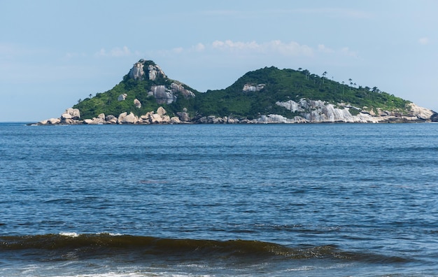 Tijuca-eilanden op de achtergrond, gezien vanaf het strand van Barra da Tijuca, Rio de Janeiro, Brazilië. Dag met blauwe lucht en wat wolken.