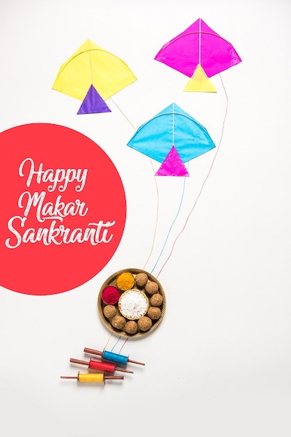 Foto til gul or sweet sesame laddu met miniatuur fikri en kite-model met haldi kumkum en suikerkristallen voor makar sankranti-festival over humeurige achtergrond, selectieve aandacht