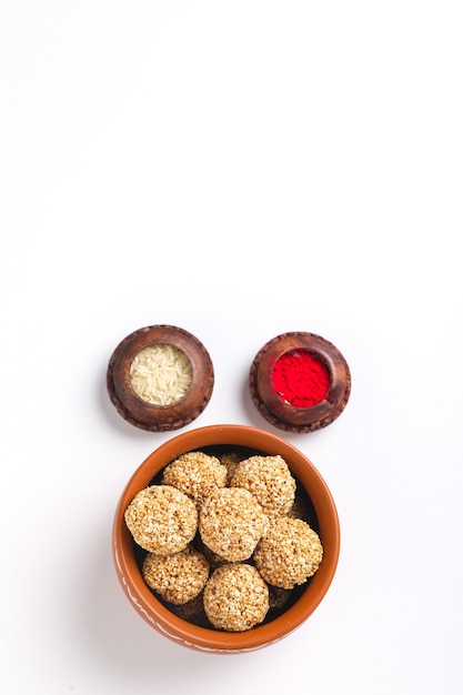 Photo til gul or sweet sesame seed ball or laddu with fikri for indian festival makar sankranti