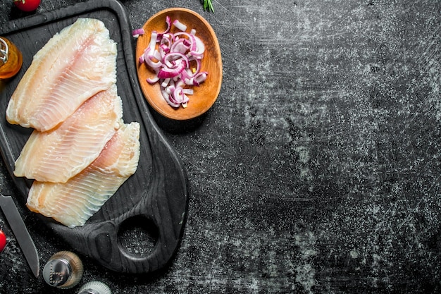 Tilapia visfilet met kruiden en ui plakjes in kommen