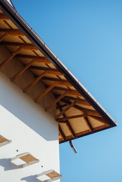 Tetto di tegole di un cottage bianco a due piani