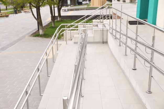 Tiled ramp with shiny metal railings outdoors