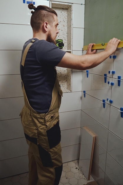 Tiler checks tile laying with building measuring level