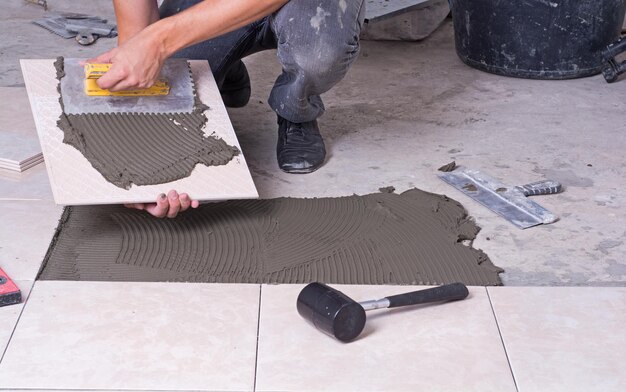 Photo tiler installing ceramic tiles on a floor